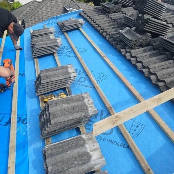 Concrete tiles stacked on new battens and membrane during a roof repair, Global Roofing and Guttering, Dublin