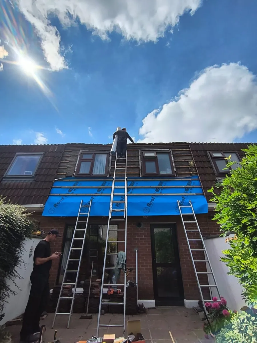 Roofer at work on a terrace dormer roof repair with ladders and new membrane, Global Roofing and Guttering, Dublin