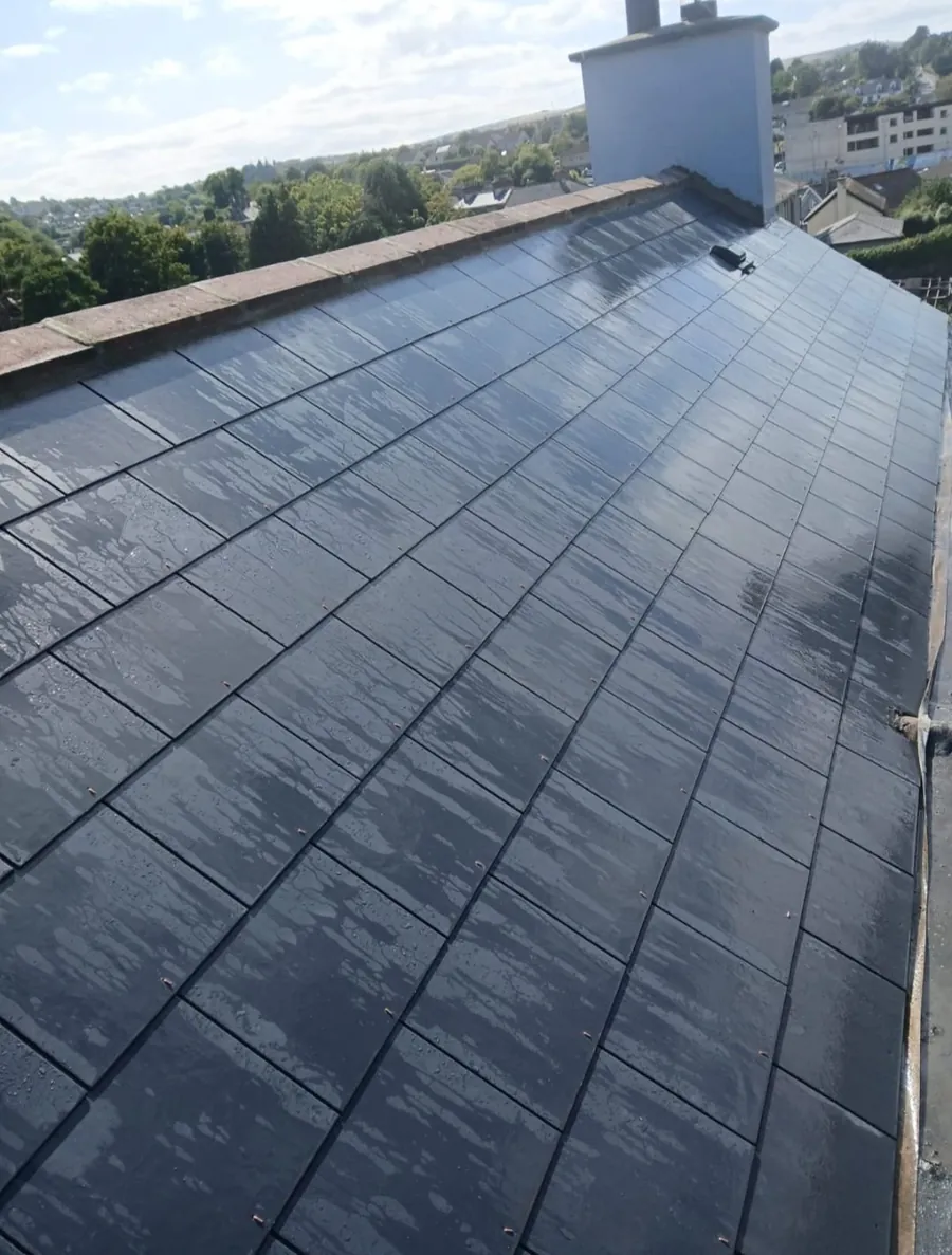 Finished new slate roof after rain with the chimney at the far end, Global Roofing and Guttering, Dublin